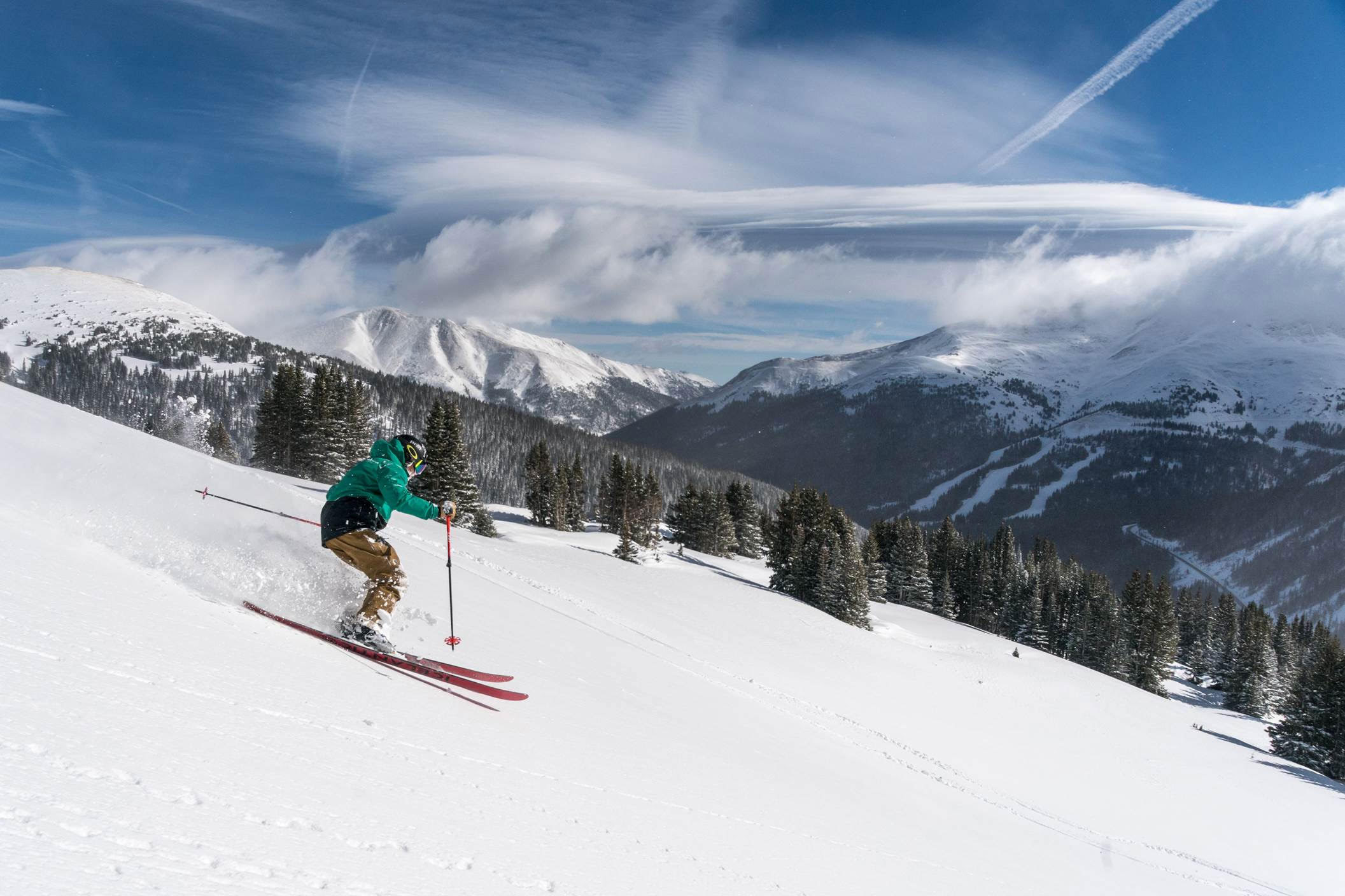 Skier dramatically sliding down the mountain at Loveland Ski Resort.