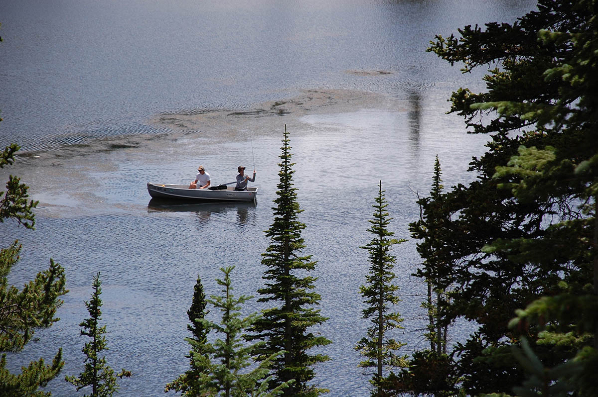 Small fishing boat floats in a lake.