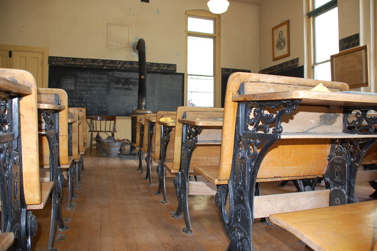 Interior of a historic school with old fashion student desks.