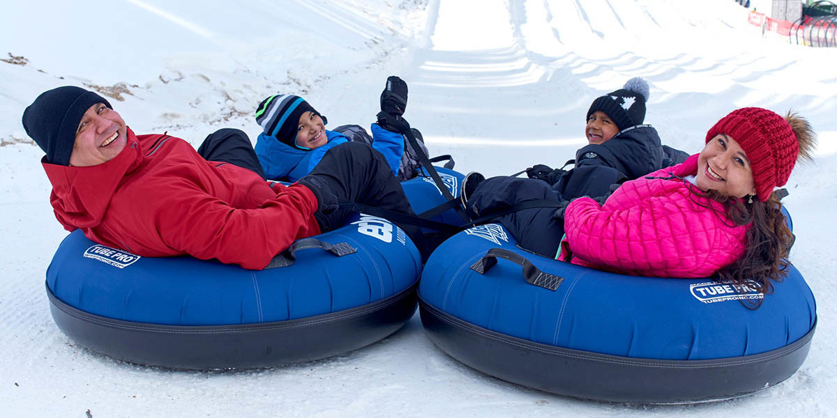 A happy family gets ready to ride down Echo Mountain’s inner tube slope.