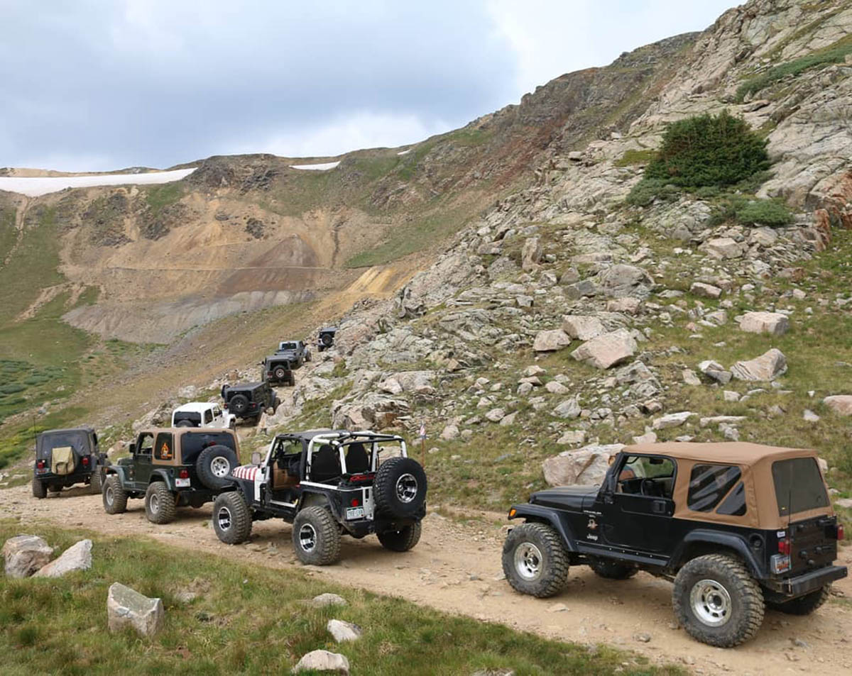 Jeeps traversing over a high-mountain pass.